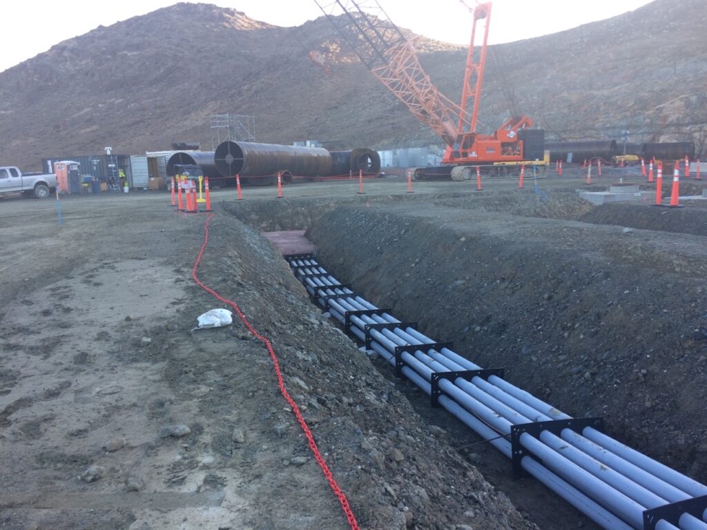 Conduit assembly supported by SP Products QwikDuct templates alongside a jobsite trench